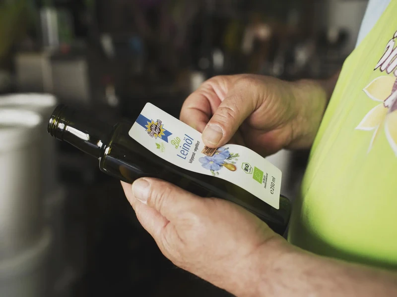 Das Etikett wird vor oder nach dem Abfüllen per Hand auf die Flasche angebracht